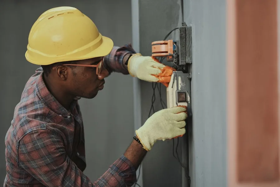 Certified HVAC technician testing an outdoor split system compressor during AC repair